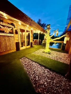 a yard with a house with lights on it at Woodland Escapes Glamping - Lake View