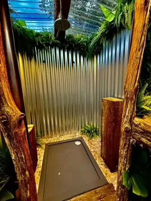 a laptop sitting on the ground in front of a fence at Woodland Escapes Glamping - Lake View