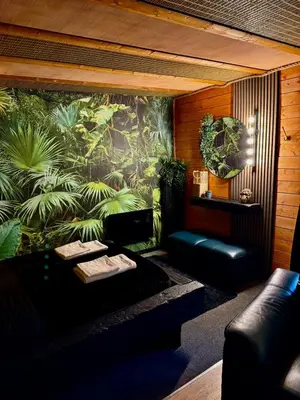 a room with a couch and a wall with plants at Woodland Escapes Glamping - Lake View