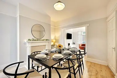 a dining room with a table and chairs and a mirror at Balfour House - Air Host & Stay - Sleeps 8, free parking in Litherland