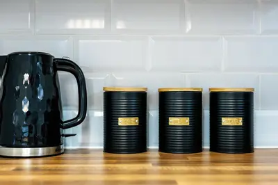 a group of four black plates next to a kettle at Balfour House - Air Host & Stay - Sleeps 8, free parking in Litherland