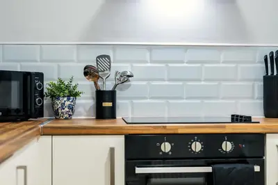 a kitchen counter with a stove and a microwave at Balfour House - Air Host & Stay - Sleeps 8, free parking in Litherland