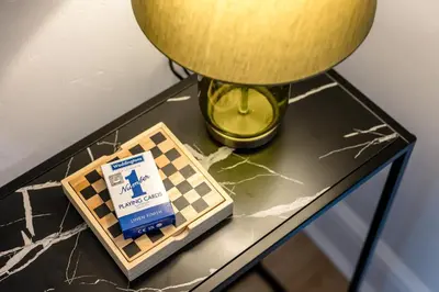 a table with a lamp and a chessboard on it at Balfour House - Air Host & Stay - Sleeps 8, free parking in Litherland