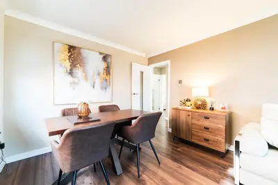 a dining room with a wooden table and chairs at 2 Bed Modern Bungalow in Darwen, Garden & Parking in Darwen