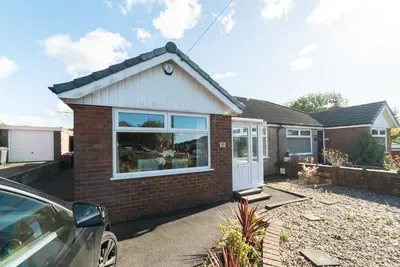 a red brick house with a white door at 2 Bed Modern Bungalow in Darwen, Garden & Parking in Darwen