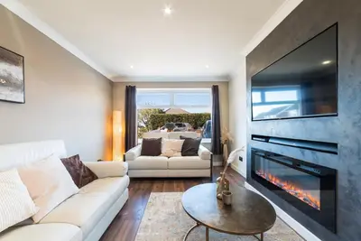 a living room with a white couch and a fireplace at 2 Bed Modern Bungalow in Darwen, Garden & Parking in Darwen