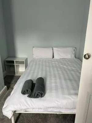 a white bed with two towels on it at ML Short Stays - 3 Bedroom House Near BAE in Barrow in Furness