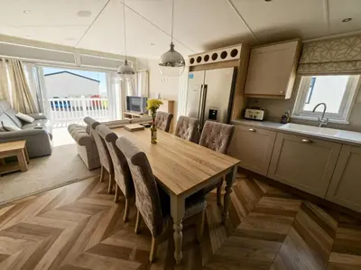 a kitchen and dining room with a wooden table and chairs at Ocean Edge Leisure Park - 21286 in Morecambe