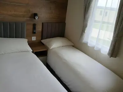 two beds in a small room with a window at Lakeland Leisure Park - 20349 in Grange Over Sands