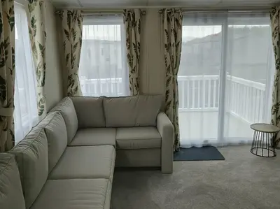 a living room with a white couch and windows at Lakeland Leisure Park - 20349 in Grange Over Sands