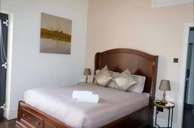 a bedroom with a bed with white sheets and pillows at Luxury City Centre Apartment in Liverpool