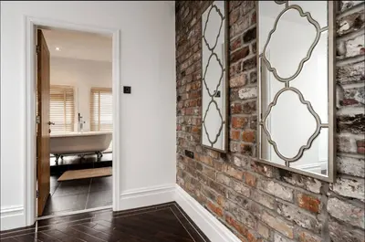 a bathroom with a brick wall and a mirror at Luxury City Centre Apartment in Liverpool
