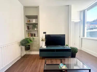 a living room with a tv and a glass table at Anfield Stadium Apartment - Perfect Matchday Stay in Liverpool