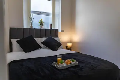 a tray of food on a bed with a drink at One Bedroom Flat by Brookland Stays Serviced Accommodation Short Lets Blackpool with Free WiFi in Blackpool