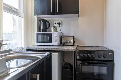 a kitchen with a stove and a microwave at One Bedroom Flat by Brookland Stays Serviced Accommodation Short Lets Blackpool with Free WiFi in Blackpool