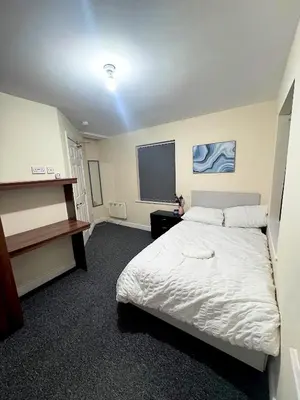 a bedroom with a white bed and a window at Cozy modern 2 bedroom apartment with comfortable lounge in Preston