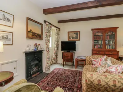 a living room with a couch and a fireplace at The Gameskeepers Cottage in Grange Over Sands