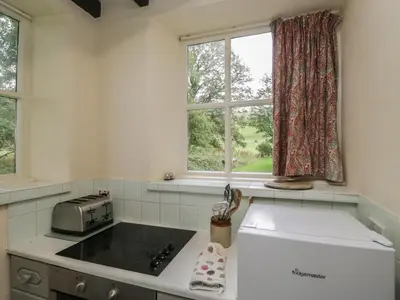 a kitchen with a sink and a window at The Gameskeepers Cottage in Grange Over Sands