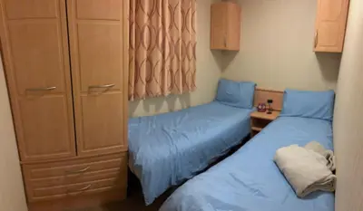 two beds in a small room with blue sheets at 167 Ashburton in Longridge