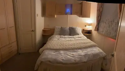 a small bedroom with a bed with white sheets and pillows at 167 Ashburton in Longridge