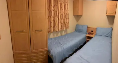 a bedroom with two beds and a dresser at 167 Ashburton in Longridge