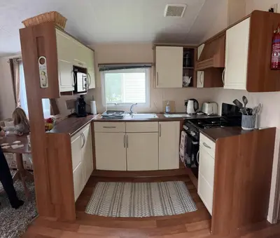 a small kitchen with white cabinets and a sink at 167 Ashburton in Longridge