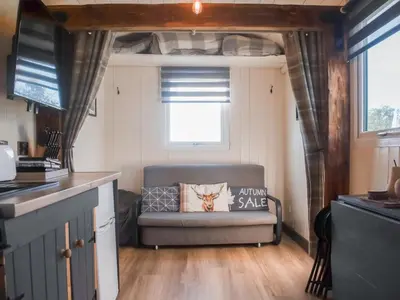 a living room with a couch in a tiny house at Shepherds Hut - Uk50043 in Chipping
