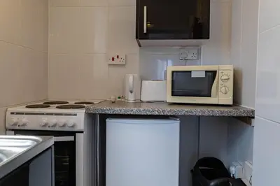 a kitchen with a counter with a microwave and a stove at One Bedroom Flat by Brookland Stays Serviced Accommodation Short Lets Blackpool with Free WiFi in Blackpool