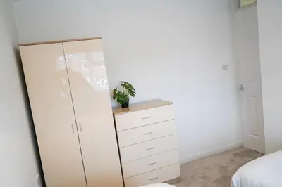 a bedroom with a large white cabinet with a potted plant at The Townhouse Liverpool in Liverpool