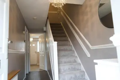 a staircase with a mirror and a chandelier at The Townhouse Liverpool in Liverpool