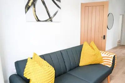 a blue couch with yellow pillows in a living room at The Butterfield in Liverpool