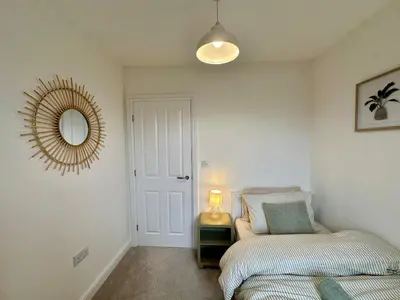 a bedroom with a bed and a mirror on the wall at The Nest at Heaton Family Friendly Near Preston and Blackpool Ample Parking and WiFi in Kirkham
