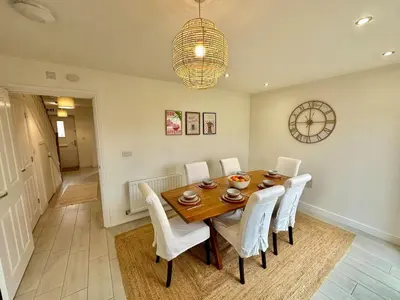 a dining room with a wooden table and white chairs at The Nest at Heaton Family Friendly Near Preston and Blackpool Ample Parking and WiFi in Kirkham