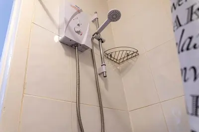 a shower with a shower head on a wall at One Bedroom Apartment by Brookland Stays Serviced Accommodation Short Lets Blackpool with Free WiFi in Blackpool