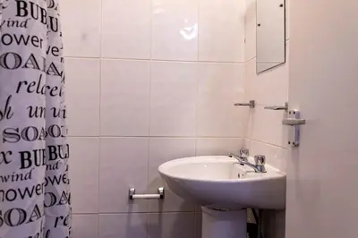 a white bathroom with a sink and a mirror at One Bedroom Apartment by Brookland Stays Serviced Accommodation Short Lets Blackpool with Free WiFi in Blackpool