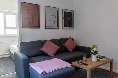 a living room with a blue couch and a table at One Bedroom Apartment by Brookland Stays Serviced Accommodation Short Lets Blackpool with Free WiFi in Blackpool