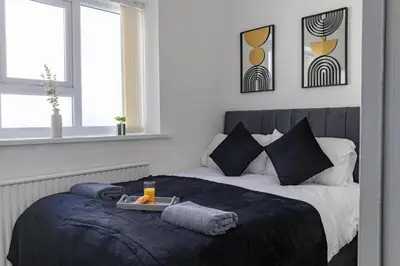 a bedroom with a bed with a tray of food on it at One Bedroom Apartment by Brookland Stays Serviced Accommodation Short Lets Blackpool with Free WiFi in Blackpool