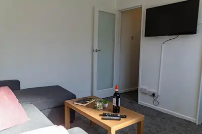 a living room with a couch and a table with a bottle of wine at One Bedroom Apartment by Brookland Stays Serviced Accommodation Short Lets Blackpool with Free WiFi in Blackpool