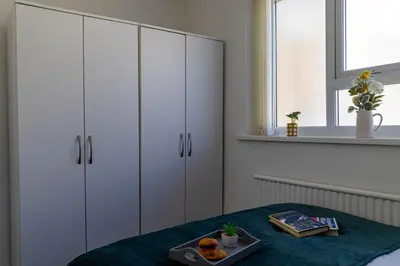 a bedroom with white cabinets and a tray of fruit on a table at One Bedroom Apartment by Brookland Stays Serviced Accommodation Short Lets Blackpool with Free WiFi in Blackpool