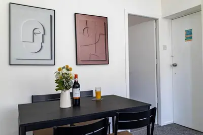 a dining room table with a bottle of wine and flowers at Brookland Stays Blackpool 1BR Apartment Sleeps 4 WiFi in Blackpool