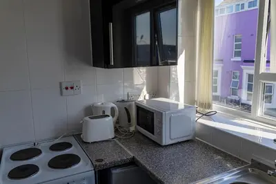 a kitchen with a microwave and a stove and a window at Brookland Stays Blackpool 1BR Apartment Sleeps 4 WiFi in Blackpool