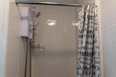 a bathroom with a shower with a shower curtain at Brookland Stays Blackpool 1BR Apartment Sleeps 4 WiFi in Blackpool