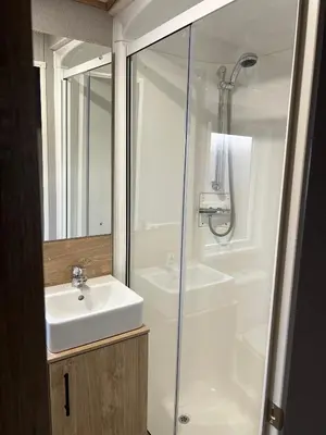 a white bathroom with a sink and a shower at Modern Caravan 2025 with Decking in Morecambe