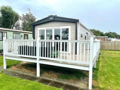 a mobile home with a porch and a white railing at Modern Caravan 2025 with Decking in Morecambe