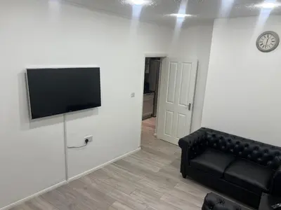a living room with a black couch and a flat screen tv at Seaside Escape in Blackpool in Blackpool