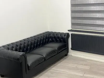 a black leather couch in a room with a window at Seaside Escape in Blackpool in Blackpool