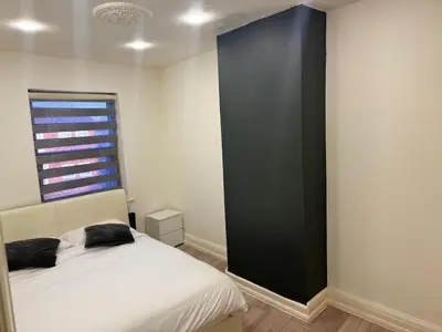 a bedroom with a white bed and a black wall at Seaside Escape in Blackpool in Blackpool