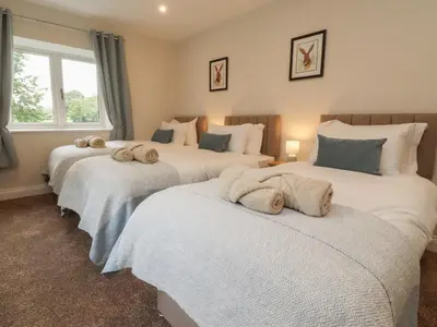 a bedroom with three beds with towels on them at Alston House in Preston
