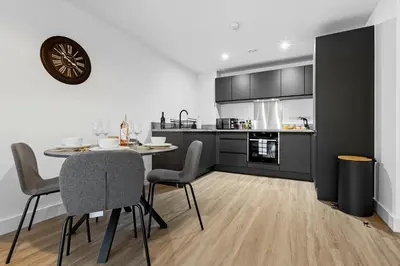 a kitchen and dining room with a table and chairs at 2BR Apt - City Centre - Parking - Balcony - Long Stays - Contractors in Liverpool