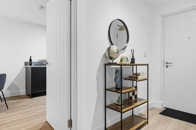 a room with a mirror and a shelf with books at 2BR Apt - City Centre - Parking - Balcony - Long Stays - Contractors in Liverpool